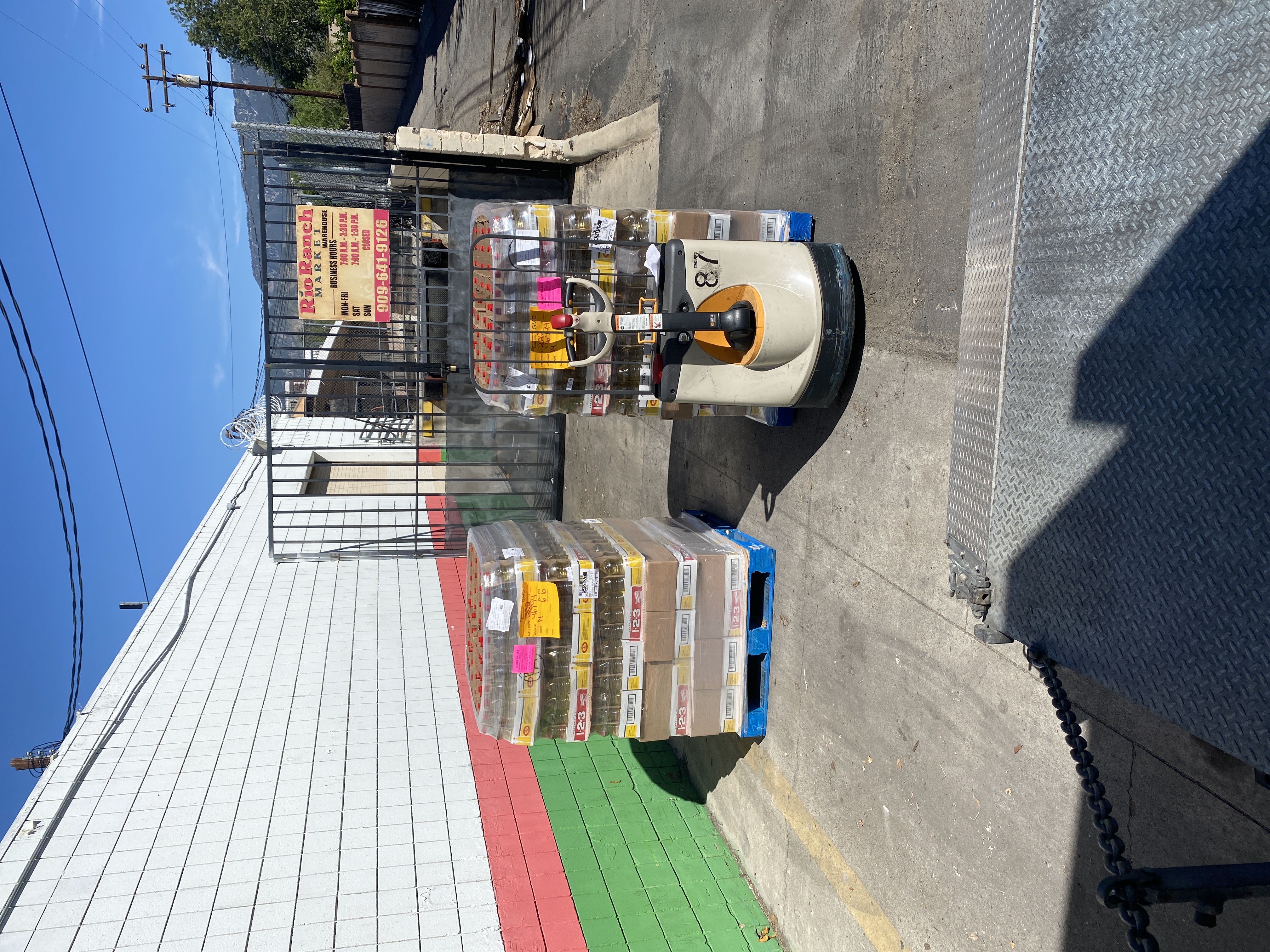 Loaded electric pallet jack moving inventory outdoors